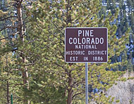 Photo of a sign that reads "Pine Colorado, National Historic District, Established in 1886".